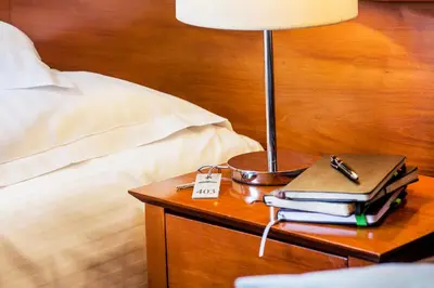 a lamp on a table next to a bed at Hotel Senacki in Kraków