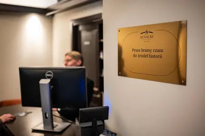 a woman sitting at a desk in front of a computer at Hotel Senacki in Kraków