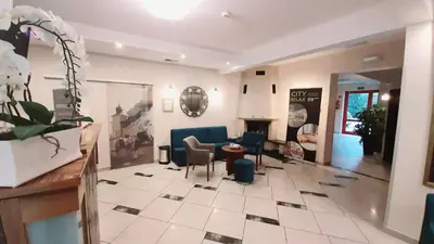 a living room with a couch and a table and chairs at Hotel City SM Business & Spa in Kraków