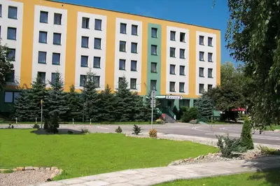 a large yellow and white building on a street at Hotel Krakus in Kraków