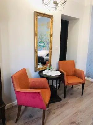a room with two chairs and a table and a mirror at Hotel Ester in Kraków