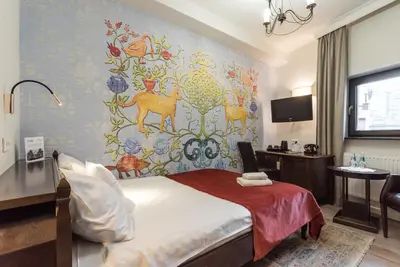 a hotel room with a bed and a wall mural at Hotel Ester in Kraków