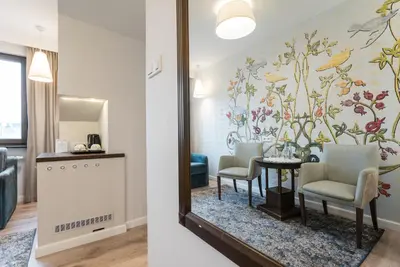 a room with a mirror and a table and chairs at Hotel Ester in Kraków