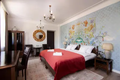 a bedroom with a large bed with a red blanket at Hotel Ester in Kraków