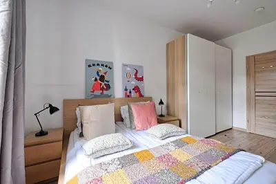 a bedroom with a bed with a quilt and pillows at Urban Nest Apartments Wietora 8 in Kraków