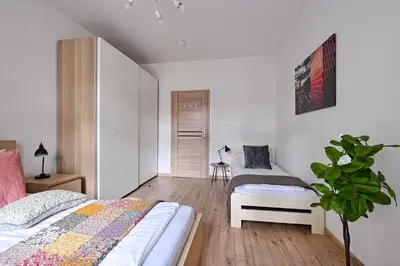 a bedroom with two beds and a potted plant at Urban Nest Apartments Wietora 8 in Kraków