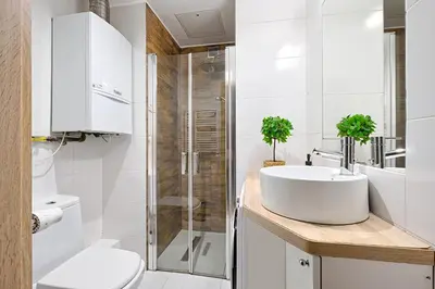 a white bathroom with a sink and a shower at Urban Nest Apartments Wietora 8 in Kraków