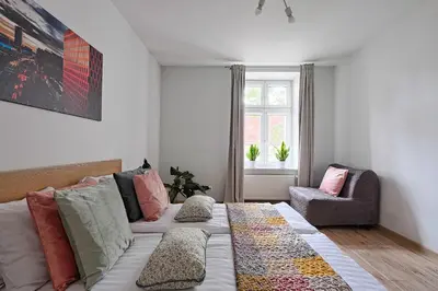 a living room with a couch and a chair at Urban Nest Apartments Wietora 8 in Kraków