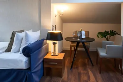 a bedroom with a bed and a table with a lamp at Nobilton Hotel in Kraków