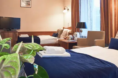 a hotel room with two beds and a tv at Nobilton Hotel in Kraków