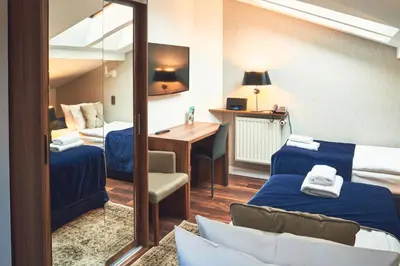 a hotel room with a mirror and a bed and a desk at Nobilton Hotel in Kraków