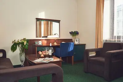 a living room with a table and chairs and a mirror at Nobilton Hotel in Kraków