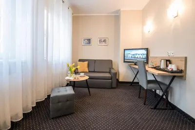 a living room with a couch and a desk with a computer at Hotel Wilga in Kraków