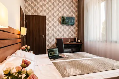 a hotel room with a bed with a laptop on it at Hotel Wilga in Kraków