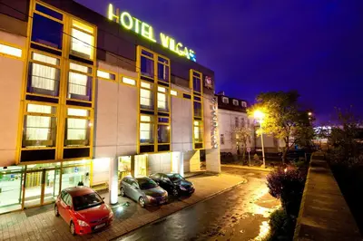 two cars parked in front of a hotel at night at Hotel Wilga in Kraków