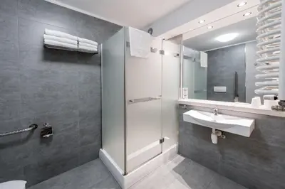 a bathroom with a sink and a shower at Hotel Wilga in Kraków