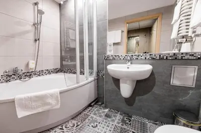 a bathroom with a sink and a tub and a toilet at Hotel Wilga in Kraków