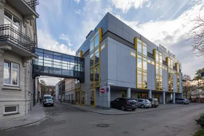 a large glass building with cars parked in front of it at Hotel Wilga in Kraków