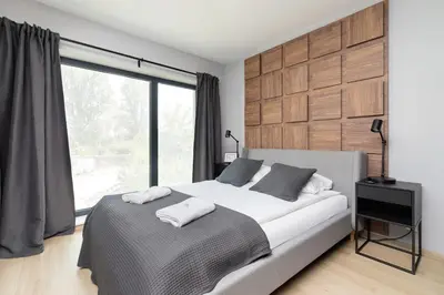 a bedroom with a bed and a large window at Modern Apartment Śródmiescie Kraków by Noclegi Renters in Kraków