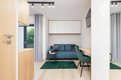 a living room with a blue couch and a table at Modern Apartment Śródmiescie Kraków by Noclegi Renters in Kraków
