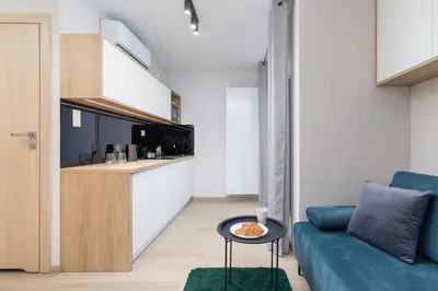 a living room with a blue couch and a table at Modern Apartment Śródmiescie Kraków by Noclegi Renters in Kraków