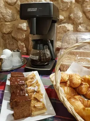 a table with a plate of desserts and a coffee maker at Hotel Eden in Kraków