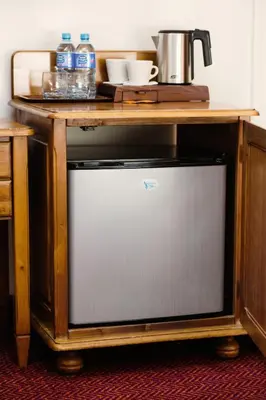 a television under a wooden table with water bottles on it at Hotel Eden in Kraków