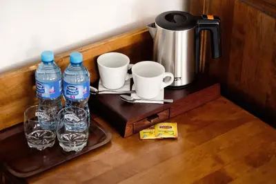 a wooden counter with two bottles of water and cups at Hotel Eden in Kraków