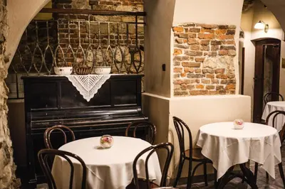 a restaurant with two tables and a piano at Hotel Eden in Kraków