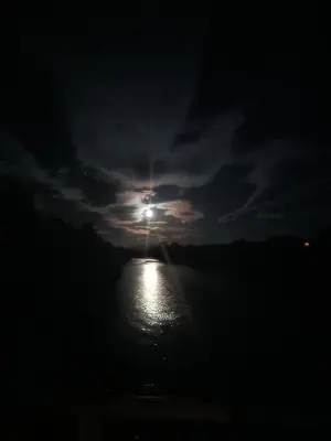a view of the sun shining on the water at night at Gościniec Dziubasowki in Nowy Targ