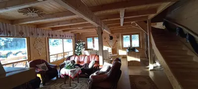a living room with couches and a staircase in a cabin at Gościniec Dziubasowki in Nowy Targ