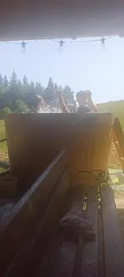 a person is sitting in a wooden box at Gościniec Dziubasowki in Nowy Targ