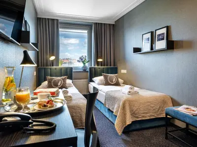 a hotel room with two beds and a table with food on it at Hotel Logos Kraków in Kraków