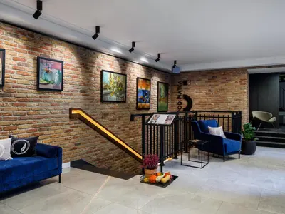 a living room with a brick wall and blue furniture at Hotel Logos Kraków in Kraków