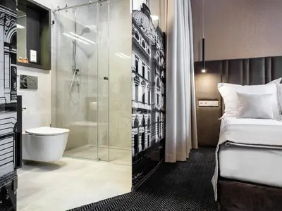 a hotel room with a shower and a bed at Hotel Logos Kraków in Kraków