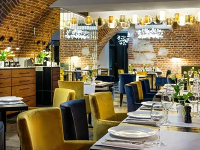 a dining room with tables and yellow chairs at Hotel Logos Kraków in Kraków