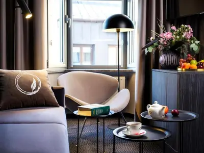 a living room with a couch and two tables at Hotel Logos Kraków in Kraków