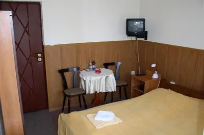 a room with a table and two chairs and a tv at Hotel Bona in Kraków