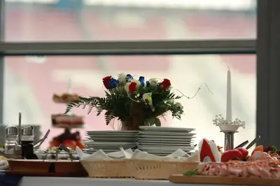 a table with plates and a vase of flowers on it at Hotel Bona in Kraków