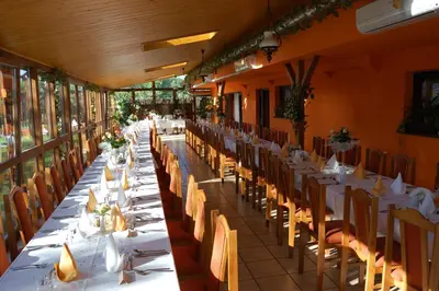 a long dining room with white tables and chairs at Hotel Bona in Kraków