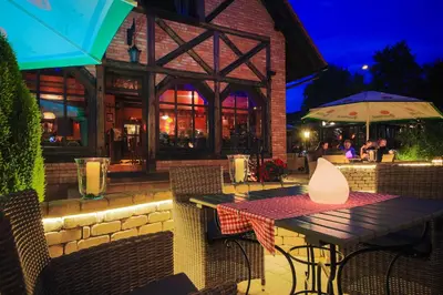 a table and chairs at a restaurant at night at Hotel Galicja Wellness & SPA in Oświęcim