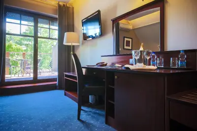 a hotel room with a desk and a mirror at Hotel Galicja Wellness & SPA in Oświęcim