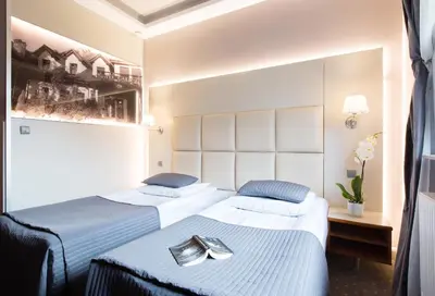 two beds in a hotel room with two folders at Hotel Galicja Wellness & SPA in Oświęcim