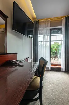 a conference room with a wooden table and a television at Hotel Galicja Wellness & SPA in Oświęcim