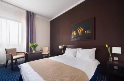 a hotel room with a bed and two chairs at Express Kraków Hotel in Kraków