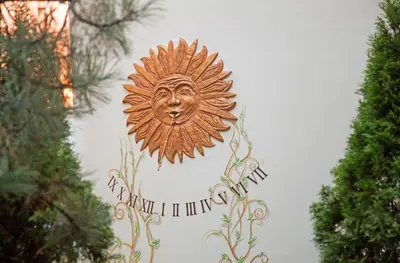 a sun sign on a wall with trees at Hotel Wawel in Kraków