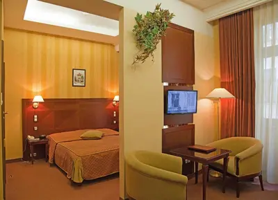 a hotel room with a bed and a table and chairs at Hotel Wawel in Kraków