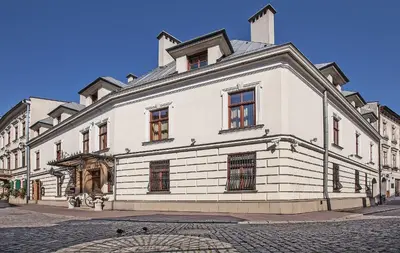 a large white building with windows on a street at Hotel Wawel in Kraków