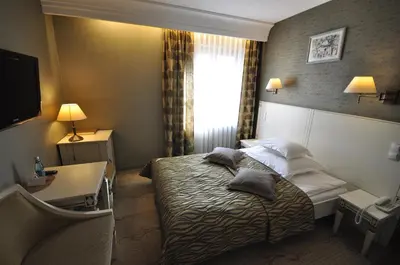 a hotel room with a bed with pillows on it at Hotel Wawel in Kraków