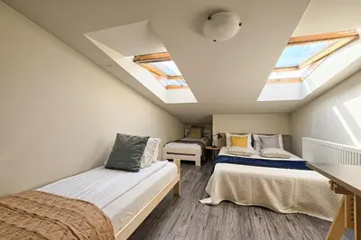 a attic bedroom with two beds and skylights at Urban Nest Apartments Radziwiłłowska 14 in Kraków